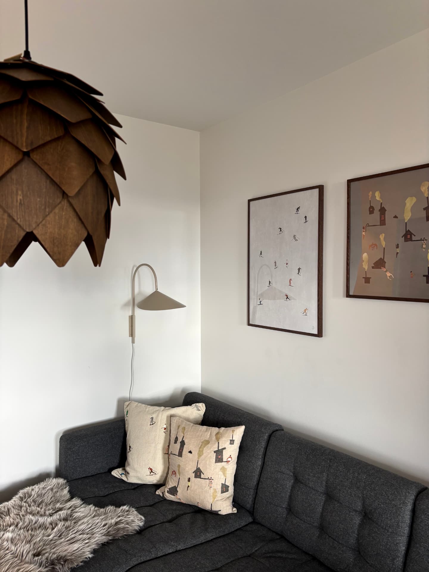Vardagsrum med soffa, designlampa och tavlor